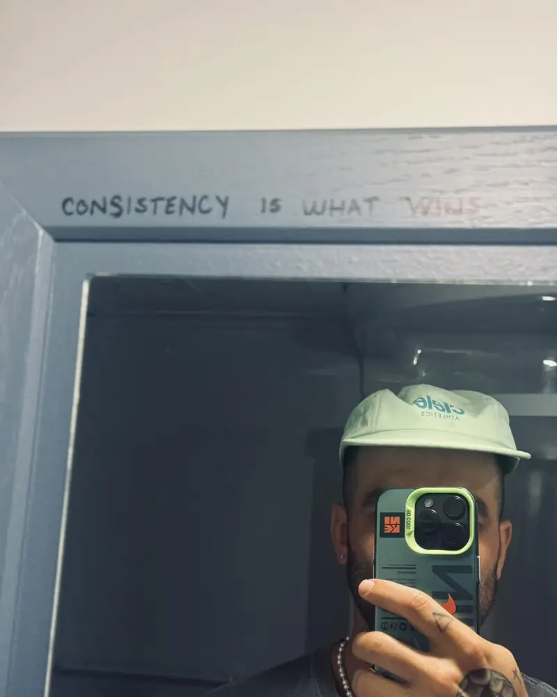 Vincent Robillard, casquette sur la tête, en égoportrait devant un miroir où il a écrit « Consistency is what wins »